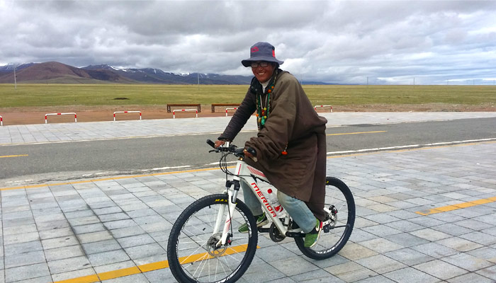 The local tibetan guide is cycling to Namtso Lake