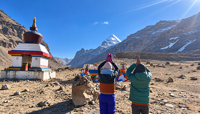 Travelers viewing Mount Kailash under clear skies