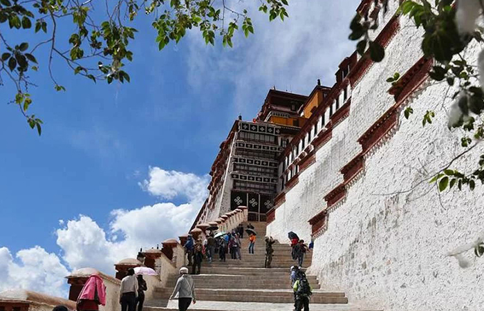 Tourists take photos as they climb Potala Palace