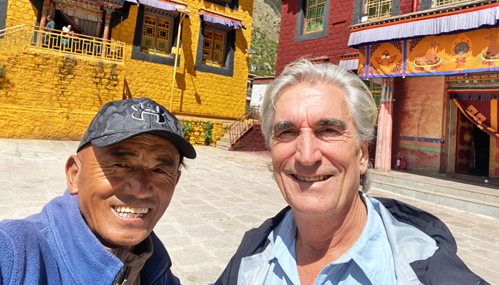 Travelers exploring Tibetan culture at a monastery with local guide